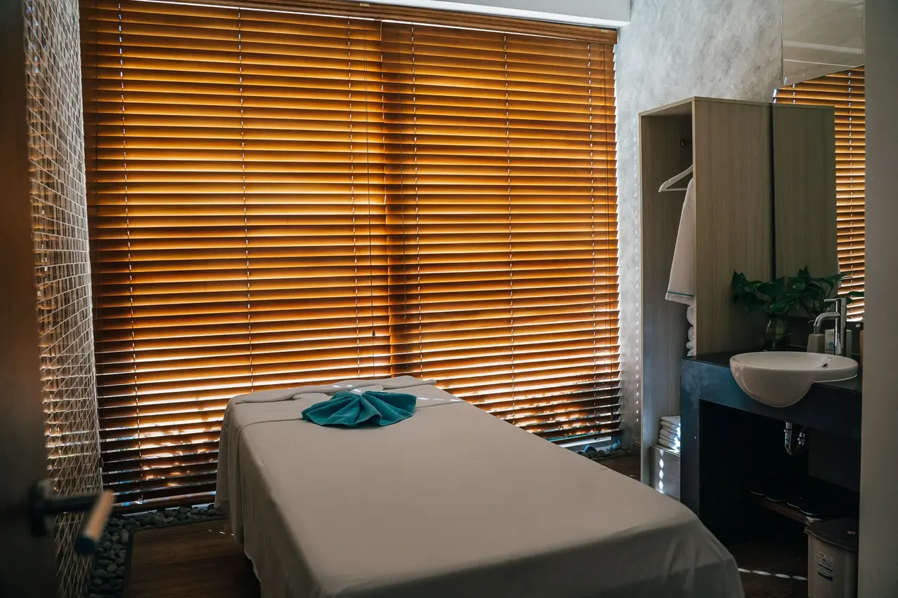 Quiet massage treatment room with a draped table and warm window light in Salt Lake City